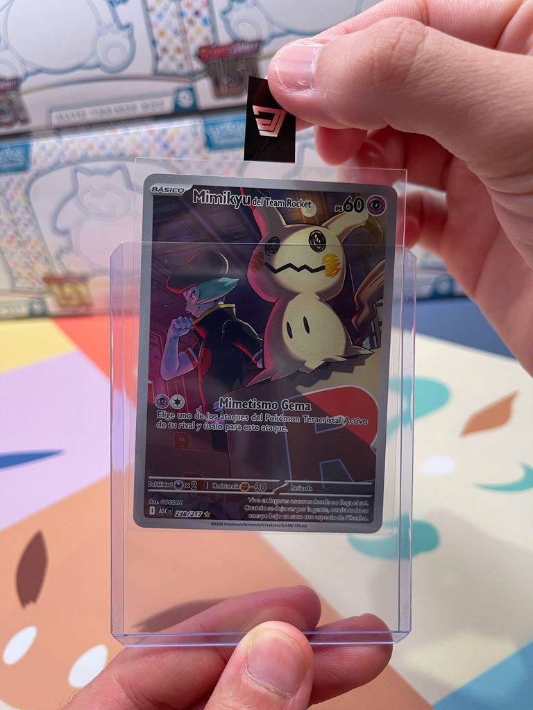 Pull Tab sobresaliendo de un Toploader con carta Pokémon