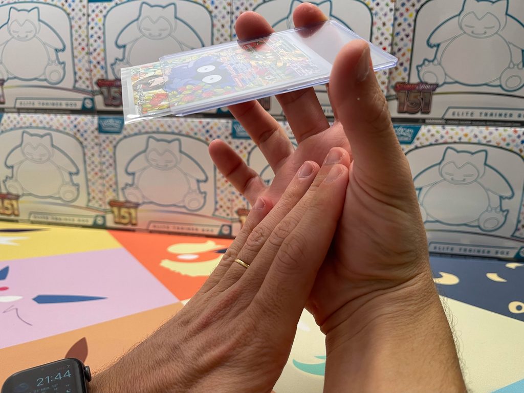 Sacando una carta Pokémon de un Toploader con la palma de la mano